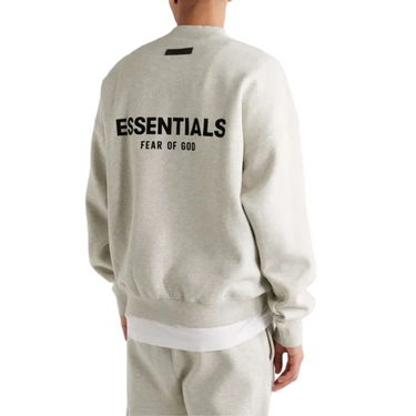 Light gray sweatshirt with 'ESSENTIALS' and 'FEAR OF GOD' text on the back, worn by a person.